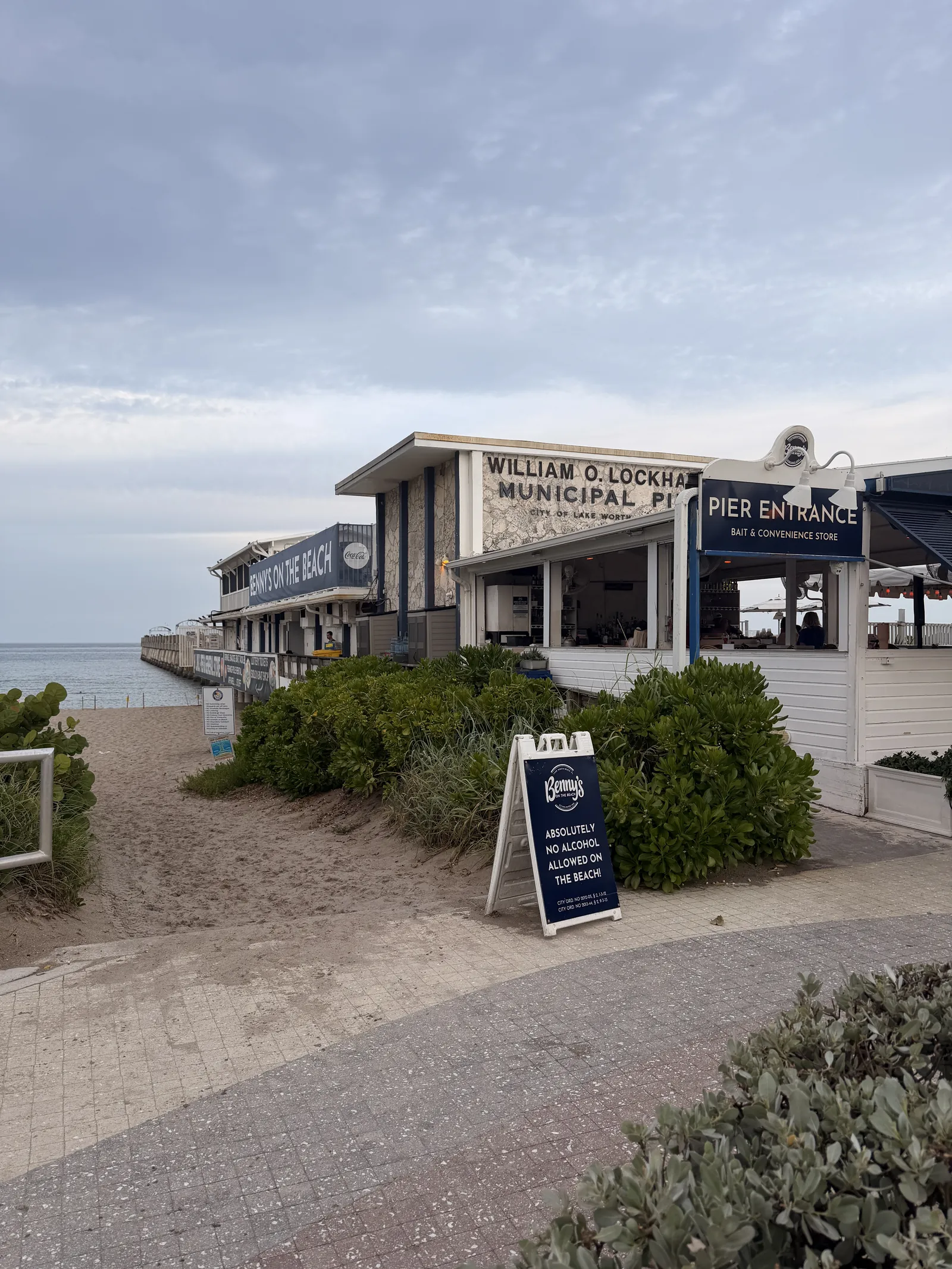 The pier entrance at Benny's, the path running down past the seating to the sand