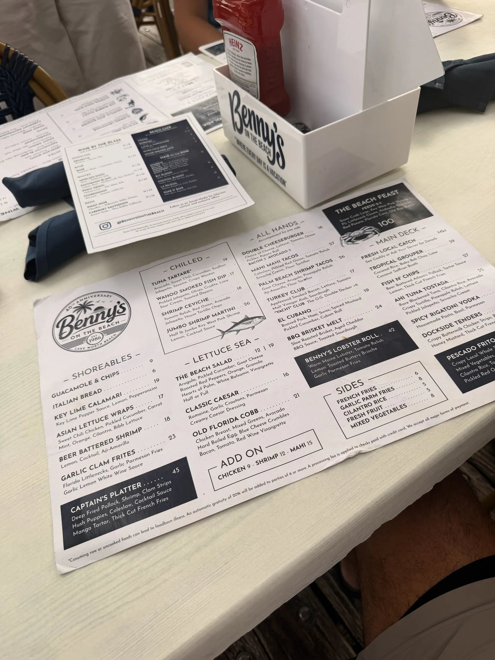 Benny's on the Beach menu open on the table, condiment caddy and napkins alongside