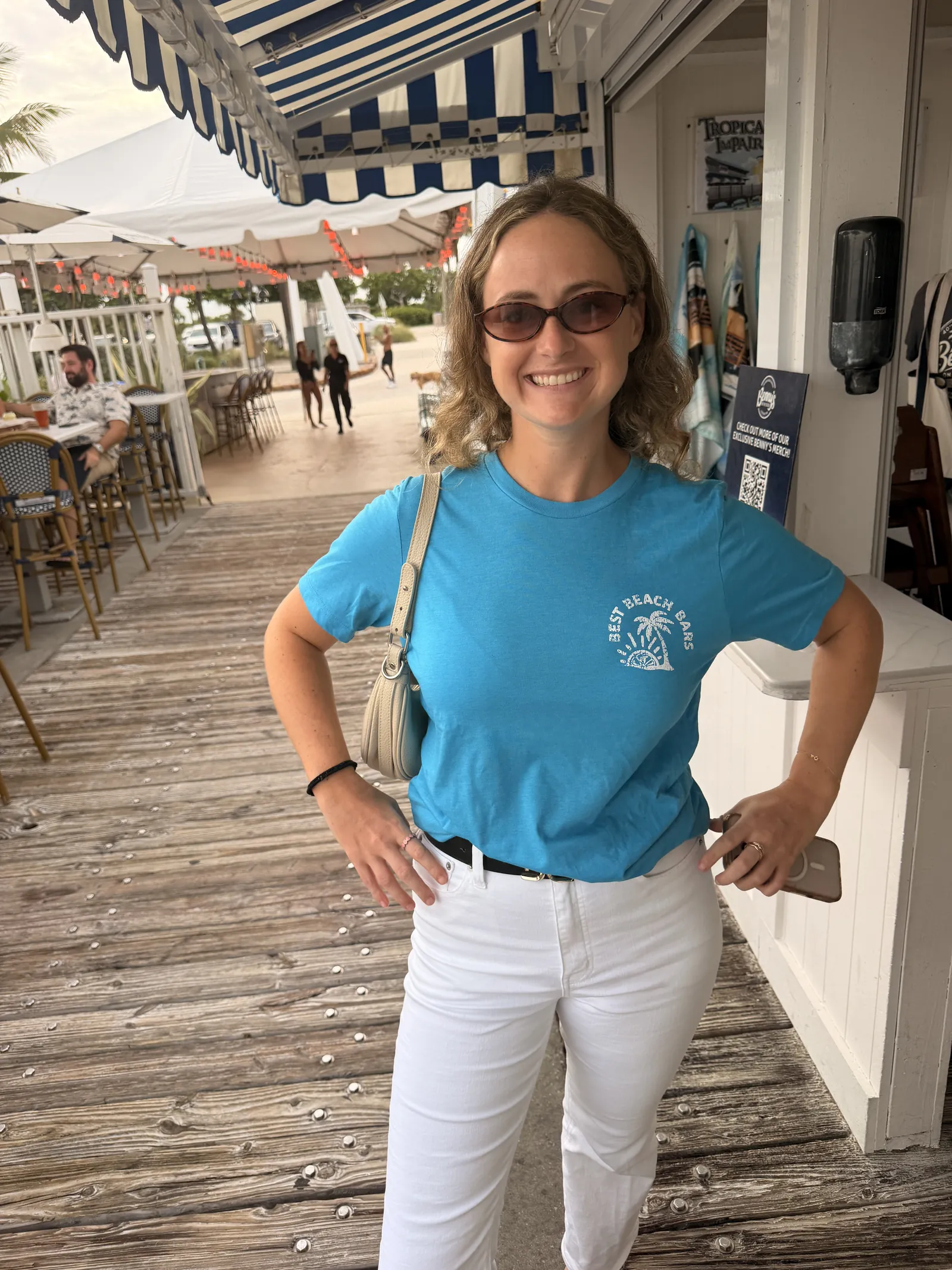 A guest on the boardwalk outside Benny's, the striped awnings running along behind