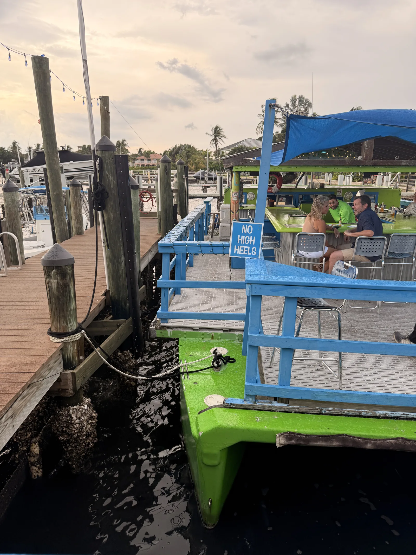 The floating bar at Old Key Lime House, a No High Heels sign and guests under the canopy