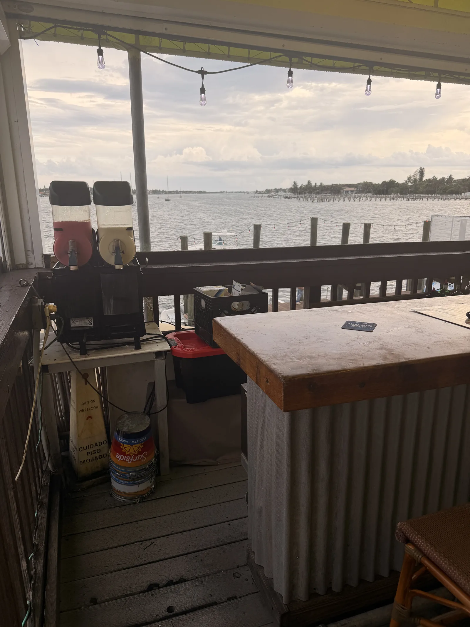 The covered bar at Old Key Lime House looking out over calm water, drink machines on the counter