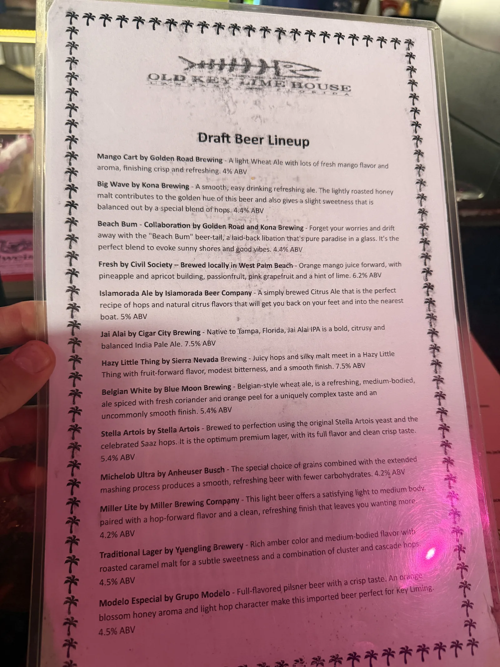 Old Key Lime House's draft beer lineup listing breweries and ABVs, palm border around the sheet