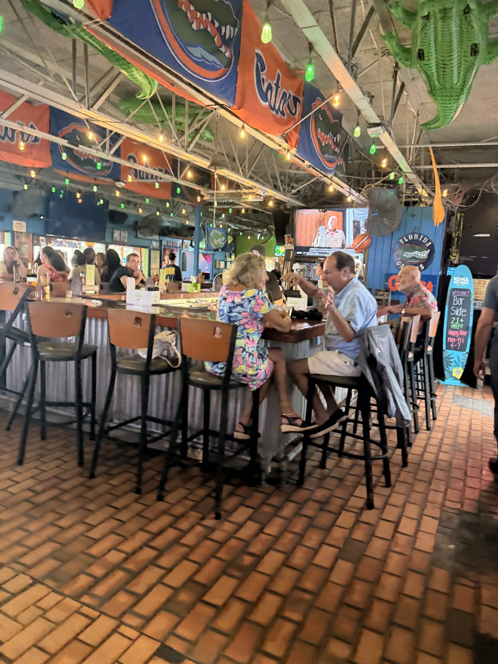 Florida Gators signs above the bar at Old Key Lime House, green lights over the brick floor