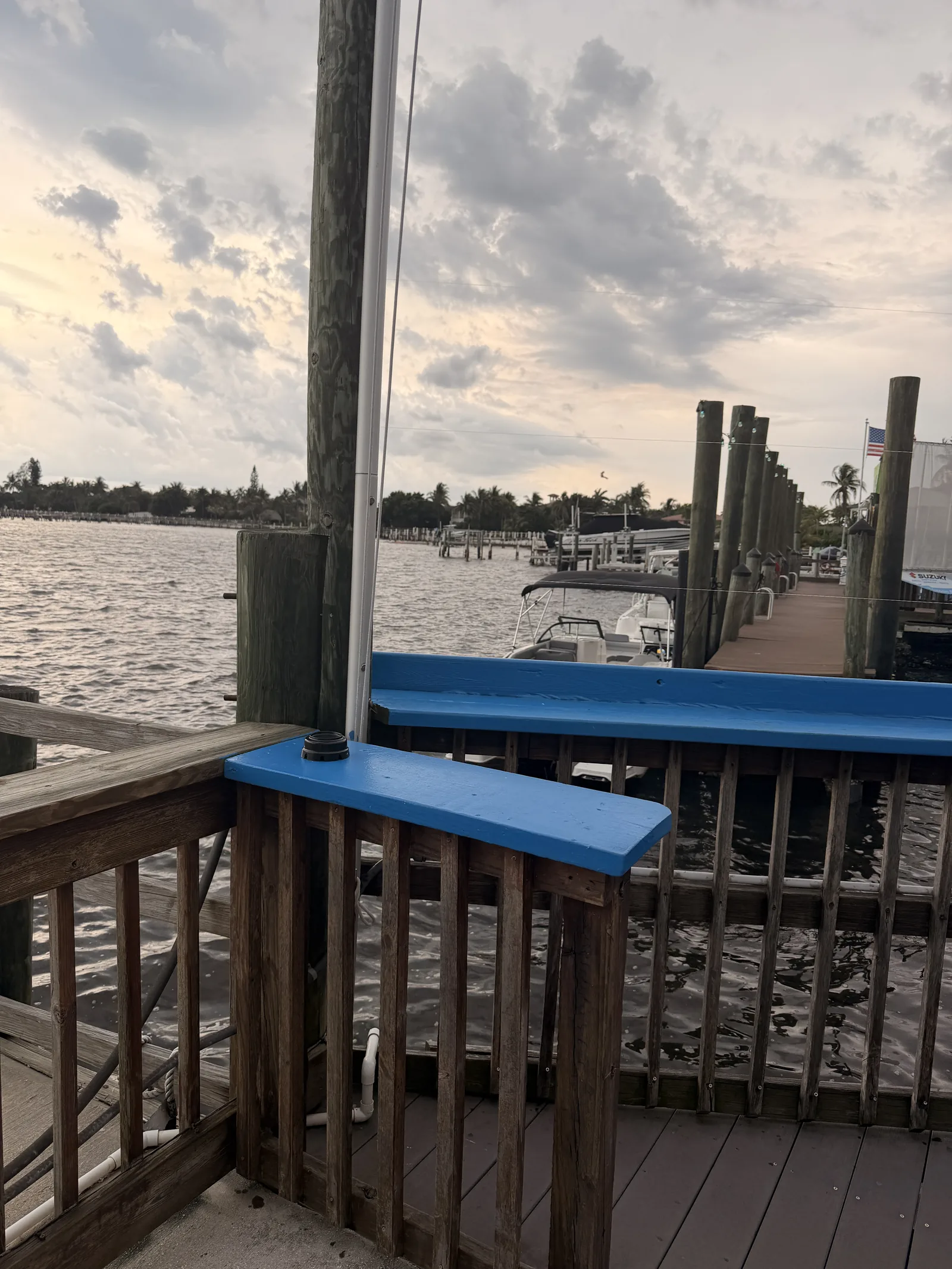 The blue-railed dock at Old Key Lime House at sunset, boats moored along the pier