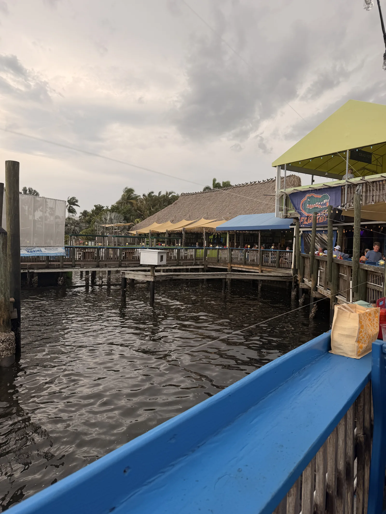 Colorful awnings over the waterfront seating at Old Key Lime House, the dock and calm water below