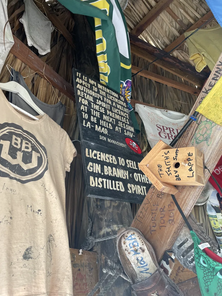 Hand-painted spirit licence boards in the rafters of Tony's Hut among signed T-shirts